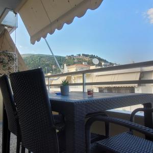 纳弗帕克托斯SOFICOS Sea View Apartment的阳台上配有桌椅和遮阳伞