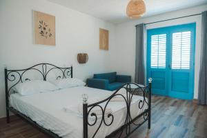 乌尔齐尼FKK艾达博亚那酒店的一间卧室配有一张床和一个蓝色的门