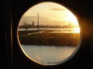 Merkem德布特酒店的透过圆形窗户欣赏日落美景