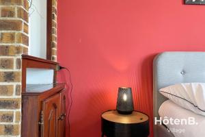 里摩日Grande maison de 140 m2 avec jardin ! 5 chambres的卧室配有红色墙壁和床边的灯