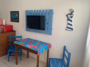 塞拉Casa beira mar Jacaraipe.的配有桌子和两把椅子以及电视的房间