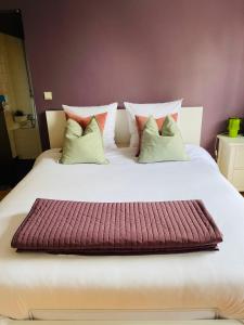 布鲁塞尔安睡公寓酒店的一张带几个枕头的大白色床