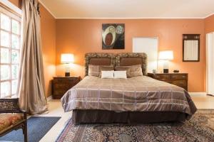 西棕榈滩Cozy House 3 large bedrooms 3full bath and king beds的一间卧室配有一张带橙色墙壁的大床