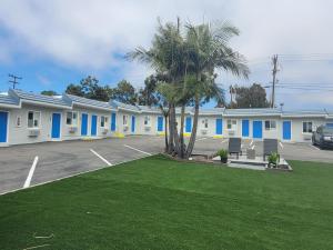 圣克莱门特Calafia Inn San Clemente Newly renovated的停车场内一排棕榈树的建筑