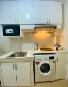 达沃市8 Spatial Condominium的厨房配有洗衣机和水槽