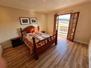坎波斯杜若尔当Casa Vila Telma的一间卧室设有一张床和一个滑动玻璃门