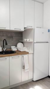 阿拉木图Apartment on Panfilova 114的厨房配有白色橱柜和白色冰箱。