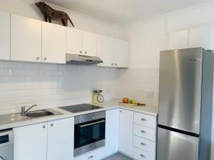 开普敦BEAUTIFUL VIEW Garden Apartment的厨房配有白色橱柜和不锈钢冰箱