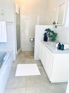 开普敦BEAUTIFUL VIEW Garden Apartment的白色的浴室设有水槽和淋浴。