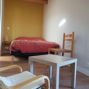圣保罗恩查拉Appartement entre lac et montagnes的配有一张床和一张桌子及椅子的房间