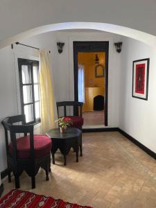 舍夫沙万达尔汉南旅馆的客厅设有两把椅子、一张桌子和一扇门