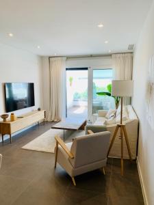 马贝拉Sea view luxury new apartment Marbella Port的客厅配有两把椅子和电视