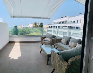 马贝拉Sea view luxury new apartment Marbella Port的大楼内的阳台配有椅子和沙发