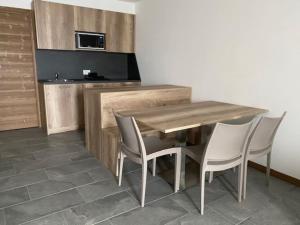 博尔米奥Appartamento trilocale luxory,sulle piste da sci的厨房配有木桌和四把椅子