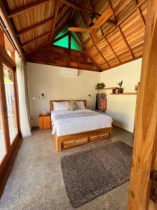 龙目岛库塔Jati Kuta Lombok的一间卧室设有一张床和木制天花板