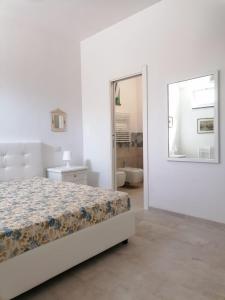 利帕里Villa Porto delle Genti的白色卧室配有床和镜子