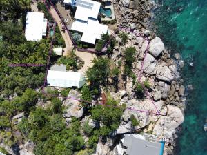 耐莉湾The Boulders - Oceanfront Couple's Retreat with private pool near ferry的近水边岩石上房屋的空中景观