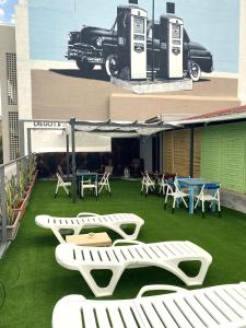 圣克鲁斯-德特内里费Tenerife Art Hostel的一座带白色椅子和汽车的庭院