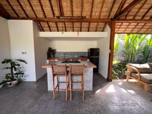 龙目岛库塔Jati Kuta Lombok的开放式厨房配有桌椅