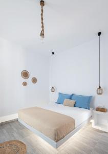 LivadakiaDorkas Luxury Rooms&Apartments的白色卧室配有一张带蓝色枕头的大床