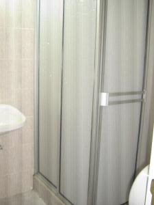 比亚维森西奥Hotel Arpa de Aguas的浴室里设有玻璃门淋浴