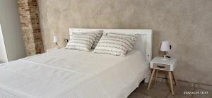 卡利亚里Castello Room & Spa的卧室配有白色的床和2个枕头