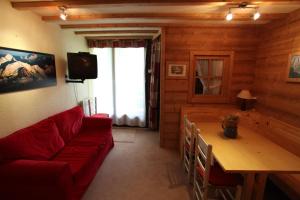 马尼戈Pan 125B的客厅配有红色的沙发和桌子