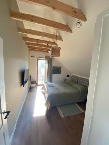 帕普Pape Apartament的铺有木地板的客房内设有一间卧室和一张床。