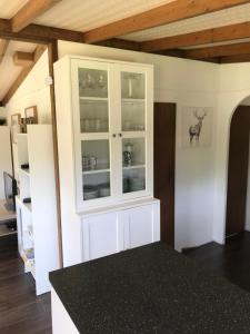 比尔斯韦尔斯Pheasant Lodge的厨房配有白色橱柜和黑色台面