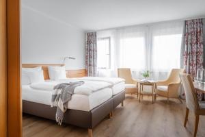 腓特烈港科隆环形酒店的白色卧室配有床和桌椅