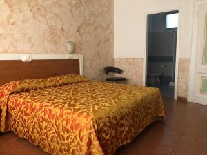帕多瓦易登酒店的一间卧室配有一张带橙色棉被的床