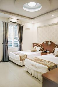下龙湾Hạ Long Starlight Hotel的酒店客房设有两张床和窗户。