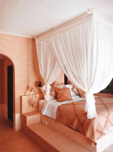 乌鲁瓦图Terra Cottages Bali的卧室配有带白色窗帘的天蓬床