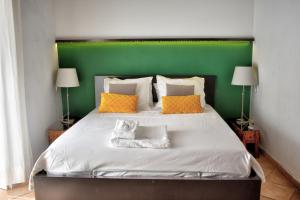 赫雷斯-德拉弗龙特拉Apartamentos Las Naranjas的一间卧室配有一张大床和绿色床头板