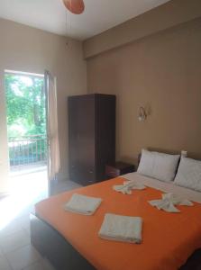 阿尔加拉斯蒂GIOTAS APARTMENTS - STUDIOS的一间卧室配有带毛巾的大型橙色床