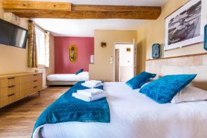 马洛塞讷Hôtel & SPA Ventoux Provence "Domaine des Tilleuls"的一间大卧室,配有两张带蓝色枕头的床