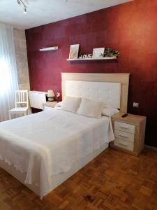 阿斯托加Apartamento Maracaibo的卧室配有一张白色大床和红色墙壁