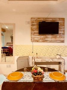 巴热Hotel Villa de Carli的一张桌子,上面有两盘,墙上有一台电视