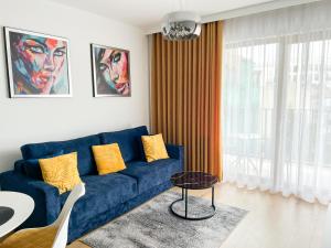 弗罗茨瓦夫Dream4You Apartments的客厅配有蓝色的沙发和桌子