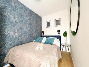 弗罗茨瓦夫Dream4You Apartments的一间卧室配有一张带蓝色图案墙壁的床