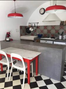 Santa-Reparata-di-BalagnaCasa Divota au cœur d’un village paisible的厨房配有红色桌子和两把白色椅子