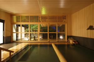 神户雷亚罗浮卡库酒店的一座带大窗户的房屋内的游泳池