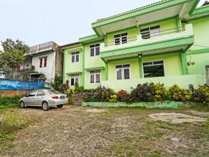 Cilimus 2SPOT ON 91325 Pondok Hijau Guest House Syariah的停在绿色建筑前面的汽车