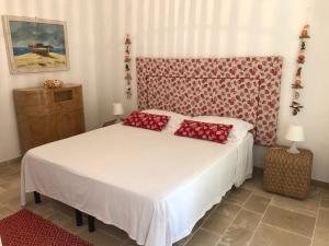 马鲁焦FICOMORO surf house的一间卧室配有一张带红色枕头的床