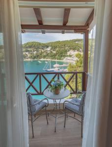 帕蒂迪里奥里阿多米雅酒店的阳台配有桌椅,水中设有船只