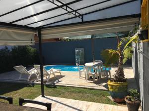 奥兰布拉recanto palmeira imperial Holambra SP的一个带桌椅的庭院和一个游泳池