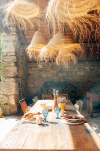 卡米尼亚Just Like Home - Quinta da Cavada em Vilar de Mouros的木桌,带盘子、玻璃杯和稻草