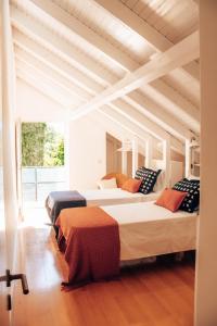 卡米尼亚Just Like Home - Quinta da Cavada em Vilar de Mouros的配有木天花板的客房内的两张床