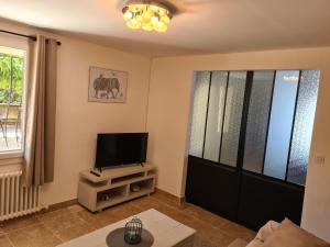 卡瓦永les olivades的客厅配有平面电视和电视架