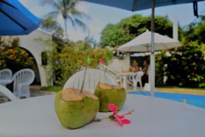 瓜拉久巴Casa das Ondas Guarajuba的两个绿色椰子坐在桌子上